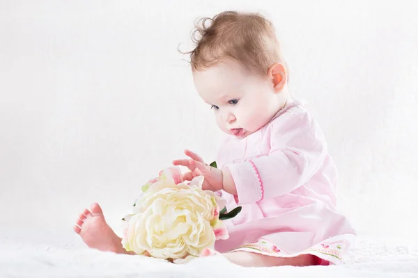 Baby girl playing with a big white flower — Stock Photo, Image