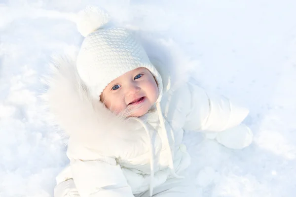 Małe dziecko siedzi w puszystym śniegu — Zdjęcie stockowe