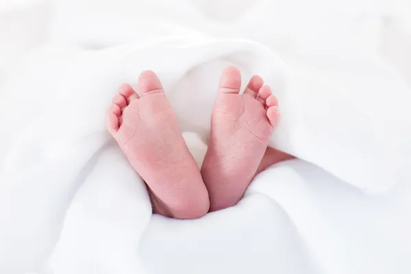 New born baby feet on a white blanket — Stock Photo, Image