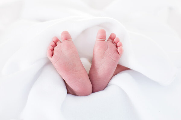 New born baby feet on a white blanket