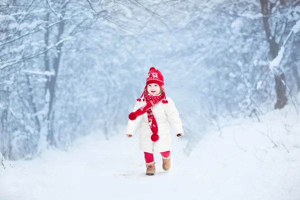 幼児の女の子が雪の公園で走っています。 — ストック写真