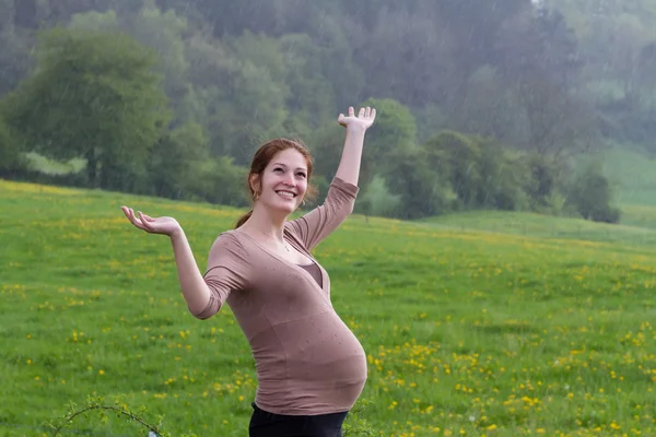 Pregnant woman walking in the rain