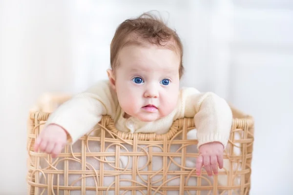 Menina bebê em uma cesta de lavanderia — Fotografia de Stock