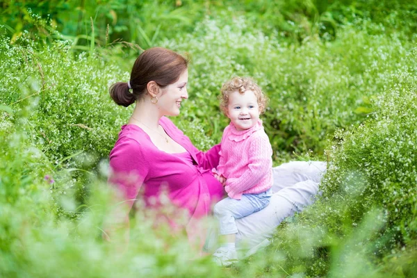 Mãe e sua filha bebê relaxando no jardim — Fotografia de Stock