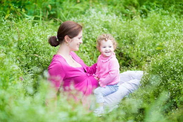 Mutter und ihre kleine Tochter entspannen sich im Garten — Stockfoto