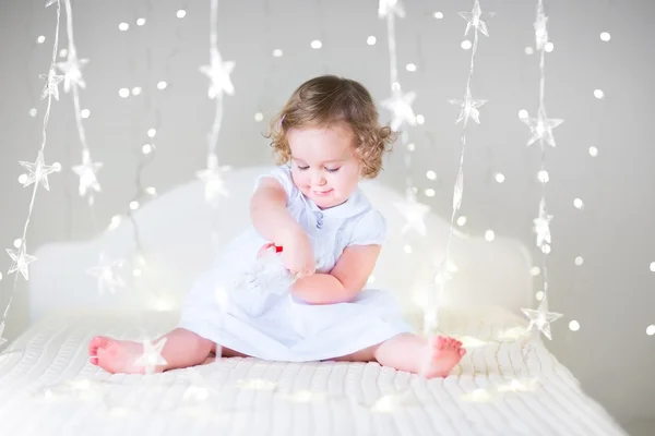 Peuter meisje spelen op een witte bed — Stockfoto