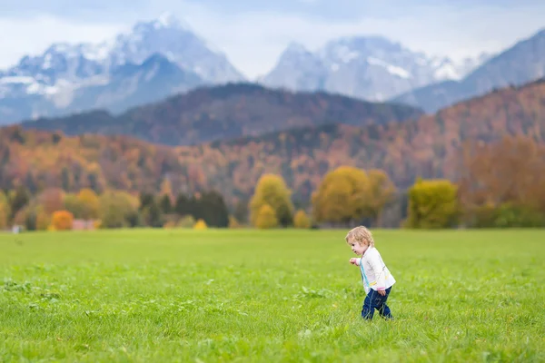 Lilla barn flicka kör i ett vackert fält — Stockfoto