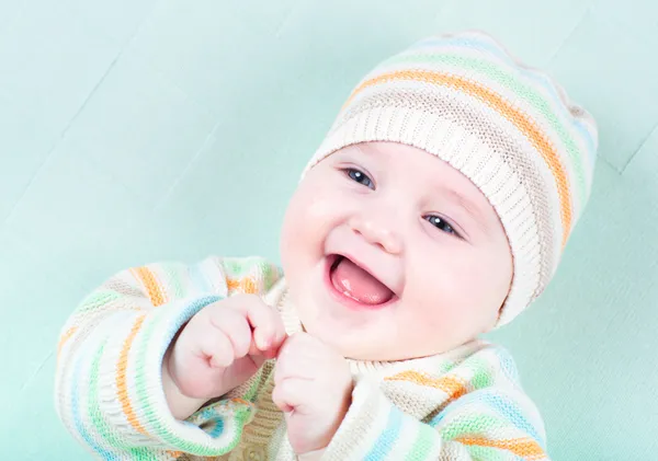 Hauska nauraa tyttö neulottu villapaita ja hattu — kuvapankkivalokuva