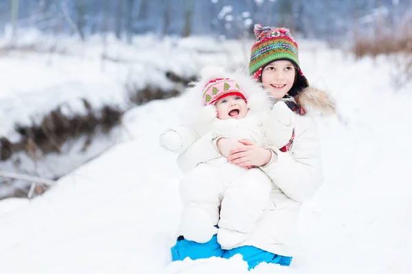 Bror och baby syster leker i snön — Stockfoto