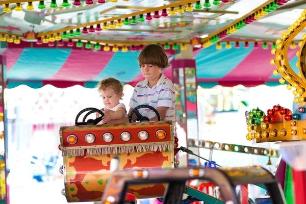 Boy and his baby sister enjoying amusement park — Stock Photo, Image