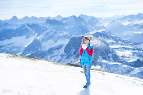 Mały chłopiec grający śnieżną kulą — Zdjęcie stockowe
