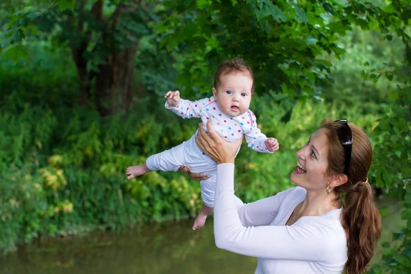 Moeder spelen met haar baby in een park — Stockfoto