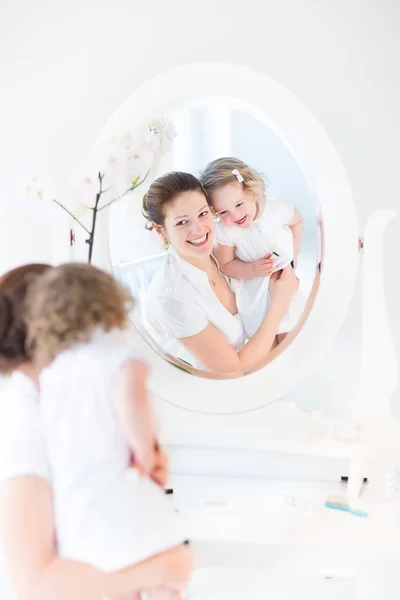 Mujer aplicando maquillaje de su hija pequeña — Foto de Stock