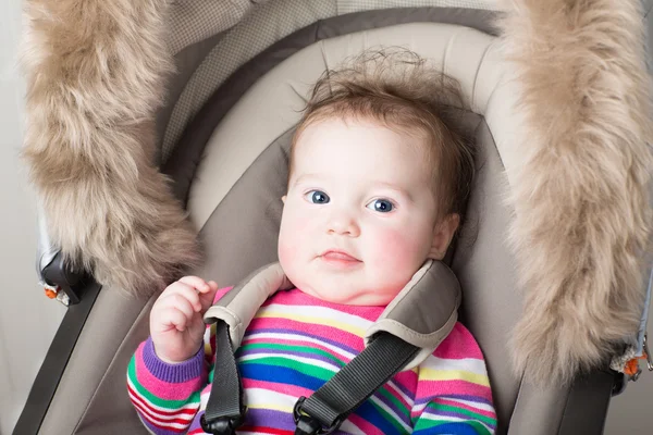Baby flicka sitter i en barnvagn — Stockfoto