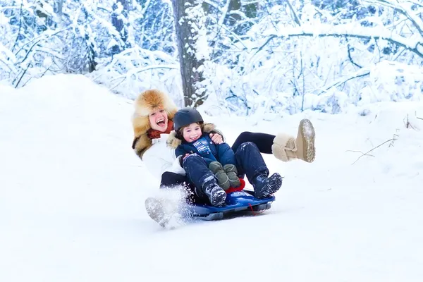 Mutter und Sohn haben Spaß auf einer Schlittenfahrt — Stockfoto