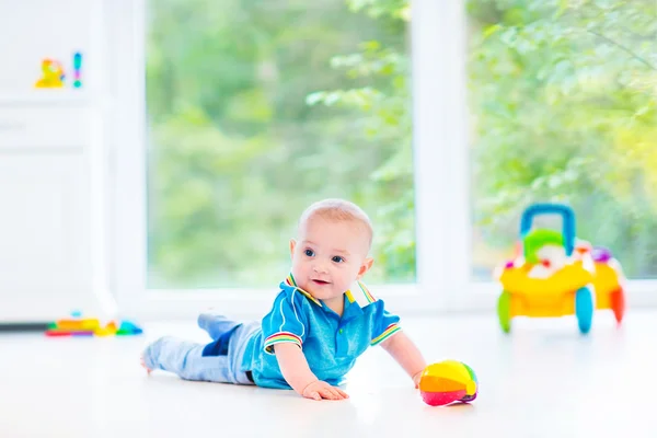 Schattige babyjongen speelt met een kleurrijke bal en speelgoed auto — Stockfoto