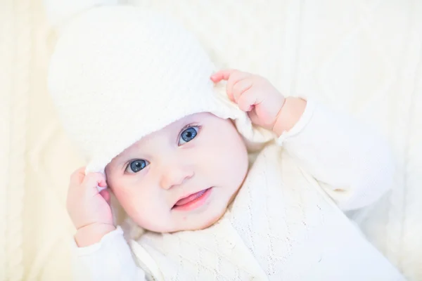 Lille baby i en hvid strikket sweater og hat - Stock-foto