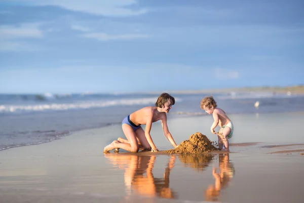 Bruder und kleine Schwester bauen eine Sandburg — Stockfoto