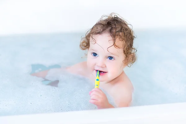 Baby mit schönen blauen Augen und lockigem Haar beim Baden — Stockfoto