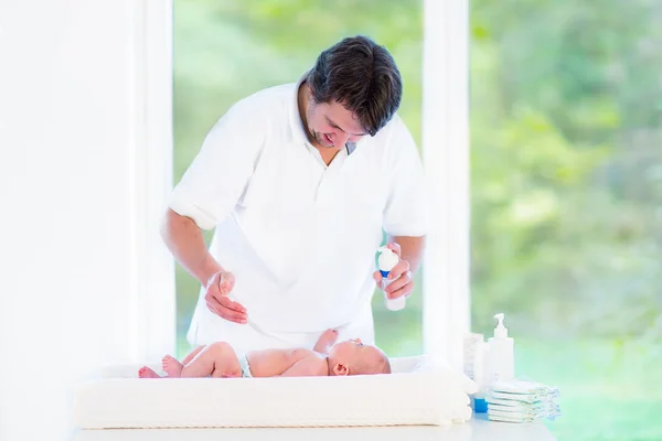 Young loving father changing diaper of his newborn baby son — Stock Photo, Image