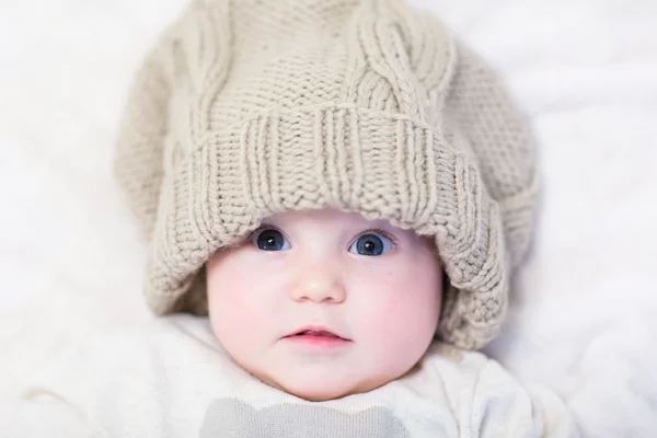 Little baby in a huge knitted hat — Stock Photo, Image