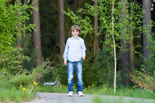 Menino andando em uma bela floresta — Fotografia de Stock