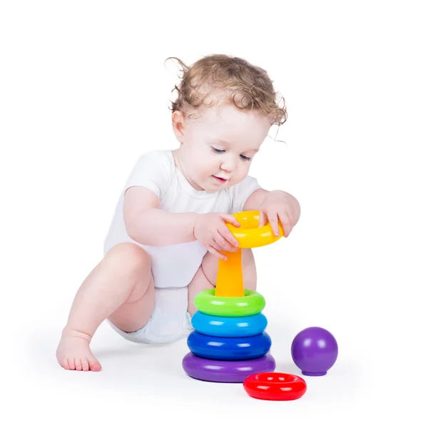 Bébé fille jouer avec une pyramide colorée — Photo