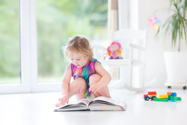 Tjej med blont lockigt hår, läsa en bok — Stockfoto