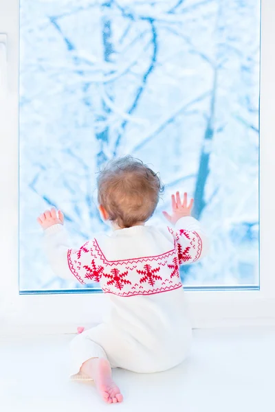 Hermosa niña sentada junto a una ventana — Foto de Stock