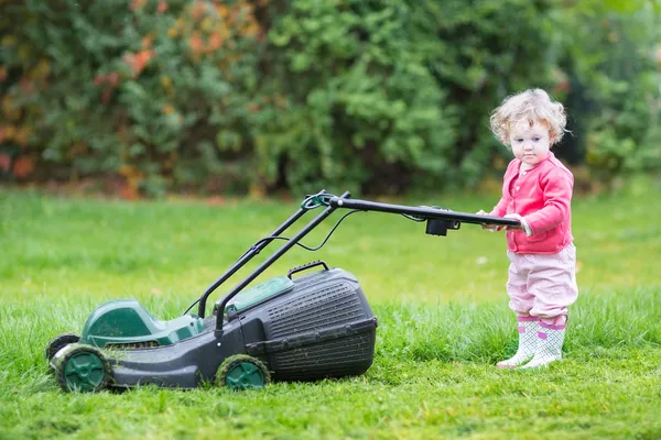 Ragazza del bambino con un tosaerba — Stockfoto