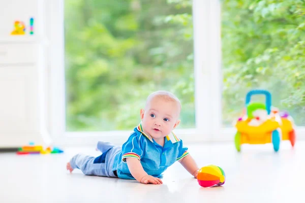 Schattige babyjongen speelt met een kleurrijke bal en speelgoed auto — Stockfoto