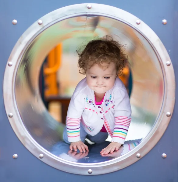 Bambina arrampicata su uno scivolo su un parco giochi — Foto Stock