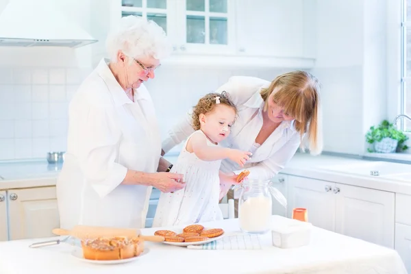 Toddler girl baking a pie with her grandmothers — Stock Photo, Image