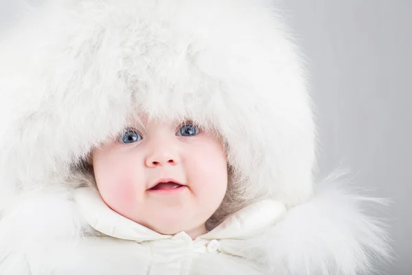 Zabawne dziecko roześmiany w duże białe futro kapelusz — Zdjęcie stockowe
