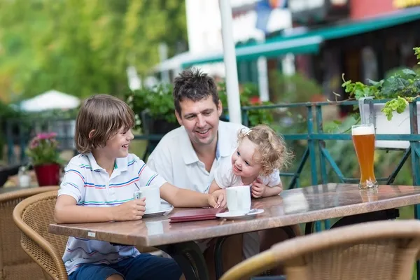 Young father enjoying a meal with his son and baby daughter — Stock Photo, Image