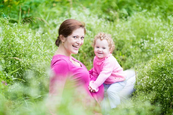 Mutter und ihre kleine Tochter entspannen sich im Garten — Stockfoto