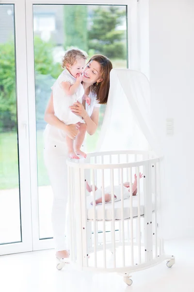 Yeni doğmuş bir bebek toddler kızı gösteren anne — Stok fotoğraf