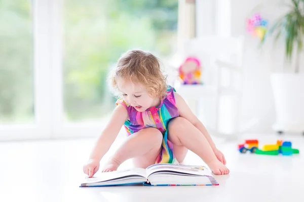 Κορίτσι με ξανθιά σγουρά μαλλιά, διαβάζοντας ένα βιβλίο — Φωτογραφία Αρχείου