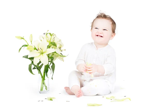 Pequeño bebé jugando con flores de lirio — Foto de Stock