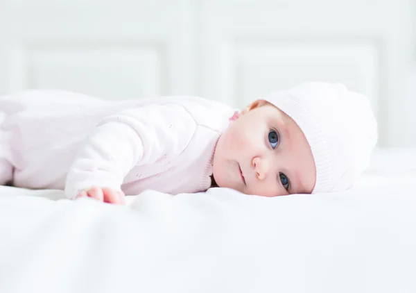 Meisje van de baby in roze gebreide muts — Stockfoto