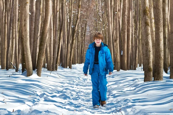 Милый мальчик, гуляющий в заснеженном лесу — стоковое фото