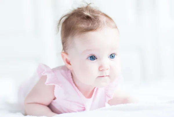 Zoete babymeisje in een roze jurk — Stockfoto