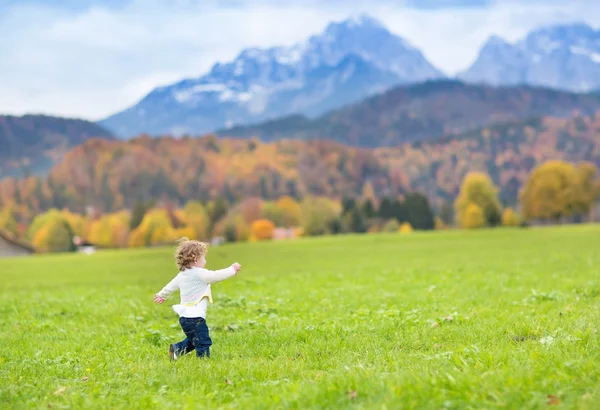 Lilla barn flicka kör i ett vackert fält — Stockfoto