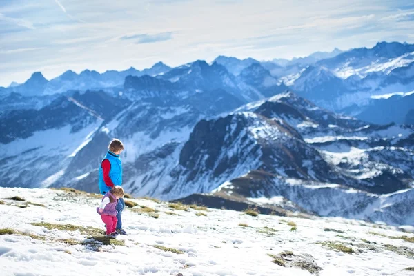 Jongen spelen met zijn kleine zusje in de sneeuw — Stockfoto