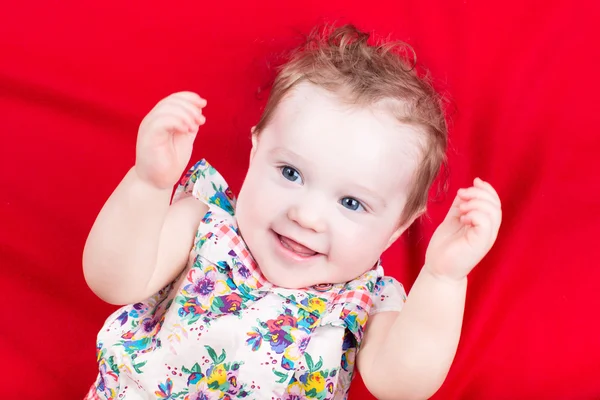 Baby girl playing on a red blanket — Stock Photo, Image