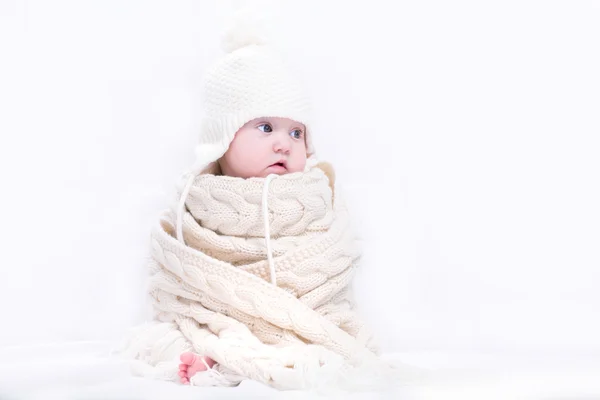 Baby in een grote gebreide sjaal en muts — Stockfoto