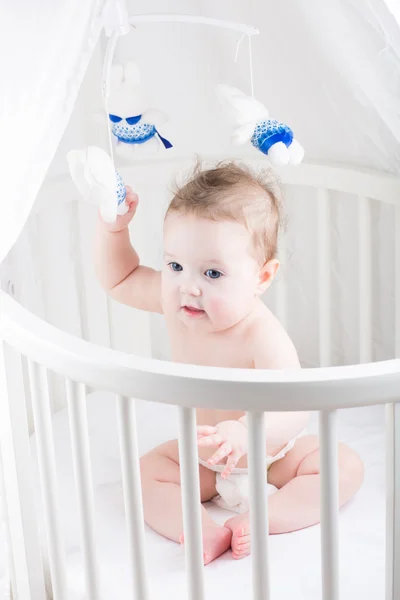 Funny baby spelar i sin spjälsäng — Stockfoto