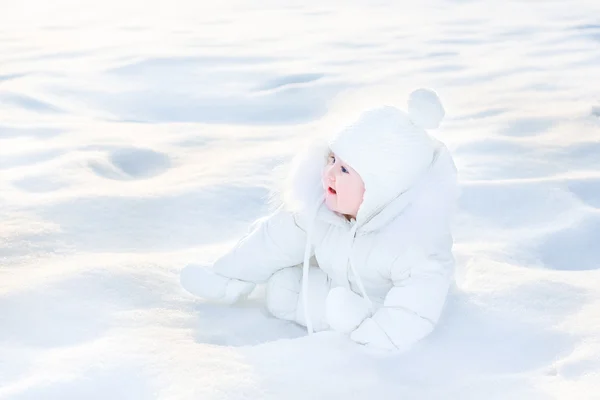 Little baby girl sitting in white snow — Stock Photo, Image