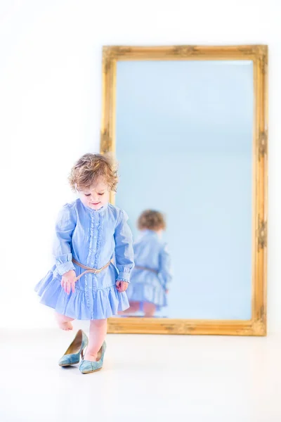 Girl standing in front of a big mirror — Stock Photo, Image