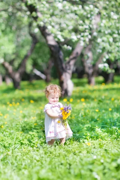 Beautiful little girl playing with flowers — Stock Photo, Image